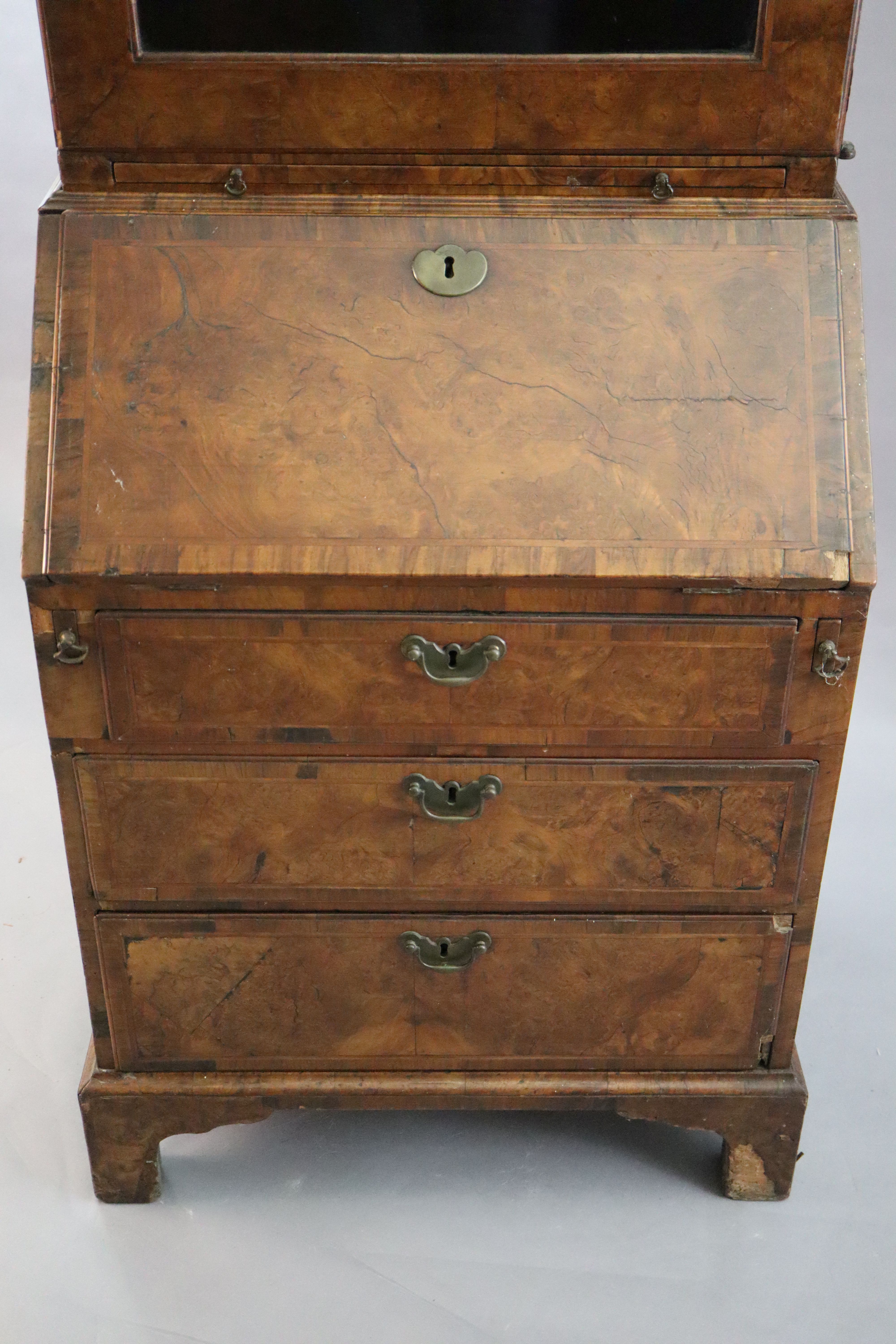 An early 18th century banded walnut bureau bookcase W. 2ft 4in. H. 6ft 6in. D. 1ft 8in.